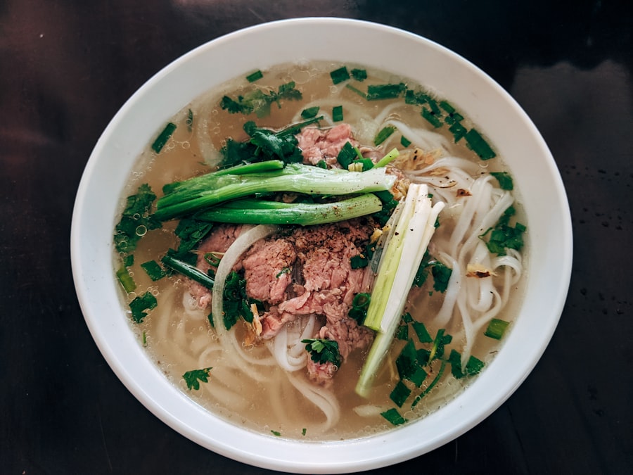 Overhead bowl of pho with herbs and lime